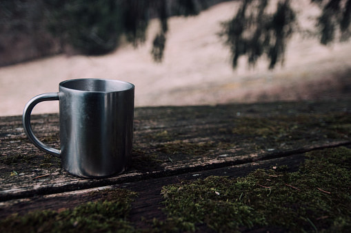 Coffee cup on old wooden table outdoors