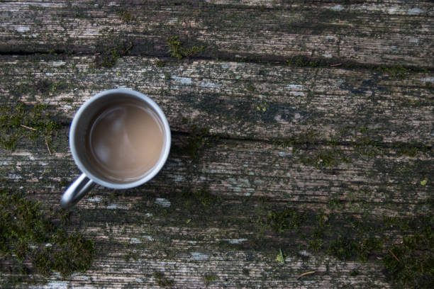 istock Coffee cup on old wooden table outdoors 905728322