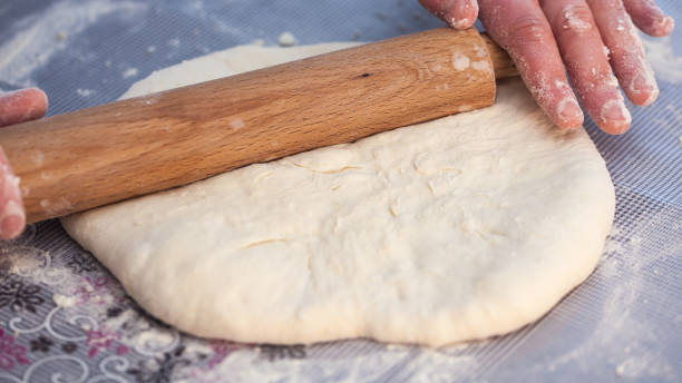 istock Baker hands preparing khachapuri on kitchen table. View on cook making traditional georgian treat with raw dough 905738956