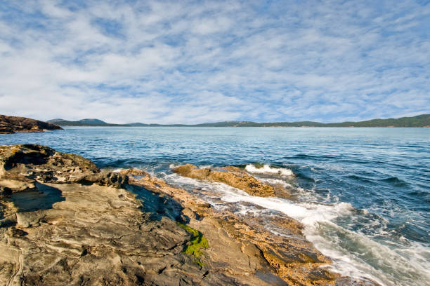 The Canadian Gulf Islands are part of a rocky archipelago in the Strait of Georgia between Vancouver Island and the mainland of British Columbia. The larger archipelago includes the San Juan Islands in the United States. The Gulf Islands are perhaps best known for their natural beauty, farms, wineries, rural lifestyle and Mediterranean climate. Activities to be enjoyed in the Gulf Islands includes boating, kayaking, hiking, camping and wildlife viewing. This area was charted by British explorer George Vancouver during his 1791-1795 expedition. The name “Gulf Islands” comes from “Gulf of Georgia,” the original name used by Vancouver on his maps. This scene of wave sculpted rocks on the Strait of Georgia was photographed from Ruckle Provincial Park on Saltspring Island, British Columbia, Canada.