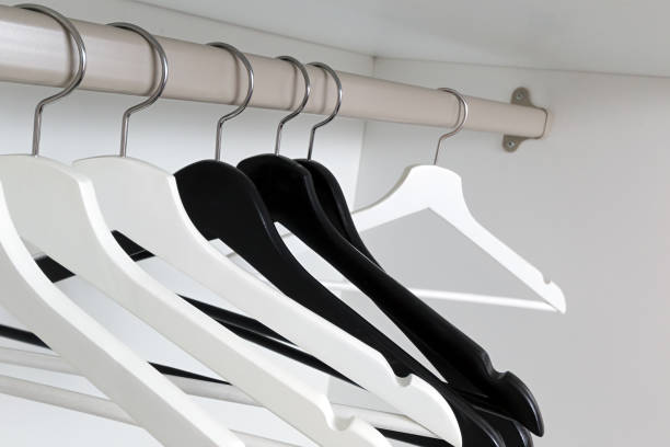 istock White and black empty clothes hangers, in the wardrobe 905751058
