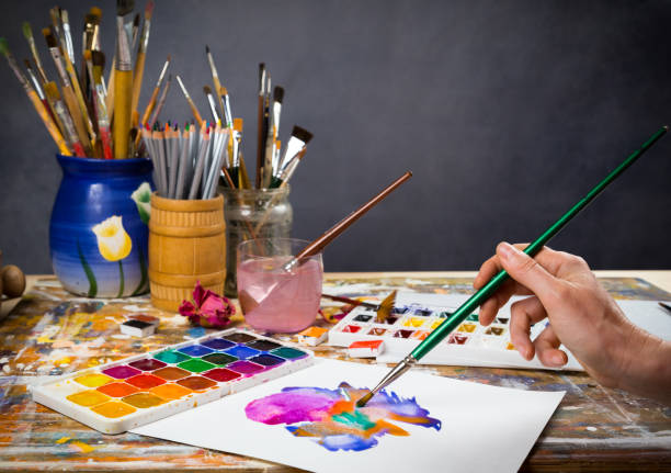 istock Hand holds the brush on the picture in the studio 905753748