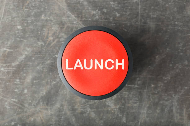 Overhead of Red 'Launch' Push Button on Concrete Background Overhead of a red circular 'Launch' push button on a concrete background push button photos stock pictures, royalty-free photos & images