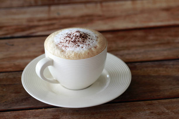 istock hot cappuccino coffee in cup on the wooden table 905754278