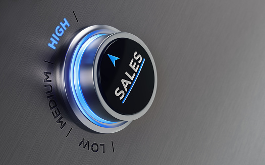 Push button on brushed metal surface. There is sales text and an arrow symbol on the button. The arrow is pointing high text on metal surface. Horizontal composition with copy space and selective focus.