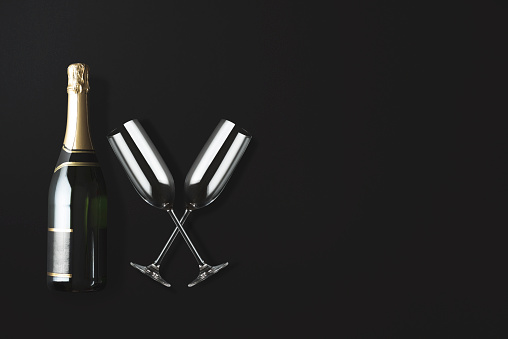 Champagne bottle and two glasses on black background