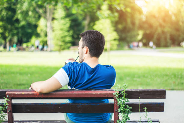 istock Young man relaxing at park with favorite coffee. 905772322