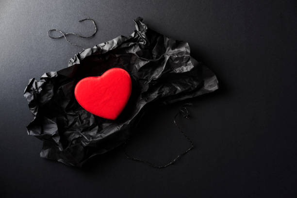 istock Red heart shaped gift box in black wrapping paper 905777690