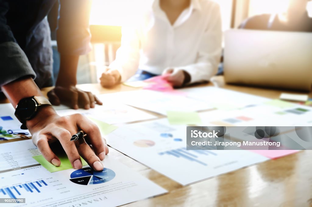 Businessman holding pens and holding graph paper are meeting to plan sales to meet targets set in next year. Organization Stock Photo