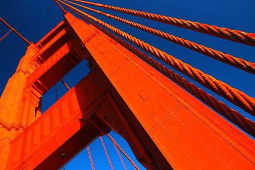 The orange anchor of the Golden Gate rises into the blue sky