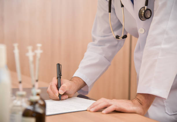 istock Asian male doctor is writing something on clipboard. 905784828