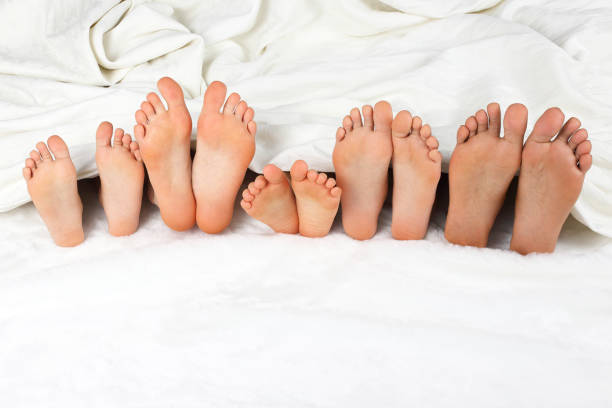 istock many children's feet peeking from under the blanket 905788750