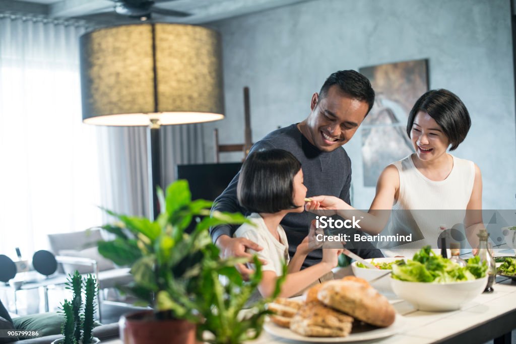 Asian family cooking at home. Happy young Asian family cooking together in the kitchen at home. Family Stock Photo