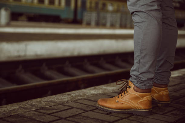 istock mans legs close up stand at the railway station 905809564