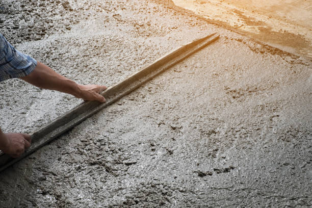 istock Workers person not wearing dirt boots digging with hoe (shovel) on concrete floor, Construction workers leveling concrete pavement. Upgrade to residential street leveling concrete slab, working place 905815500