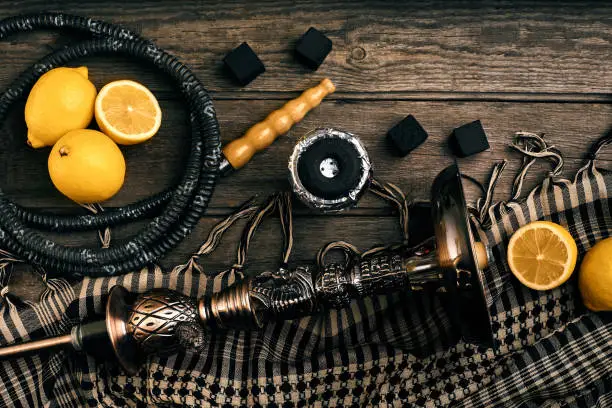 Dismantled parts of hookah on a wooden background with lemon fruit. Top view. Flat lay. Copy space. Still life