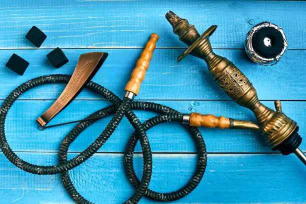 Photo of Parts of the hookah on blue wooden background. Hookah accessorie