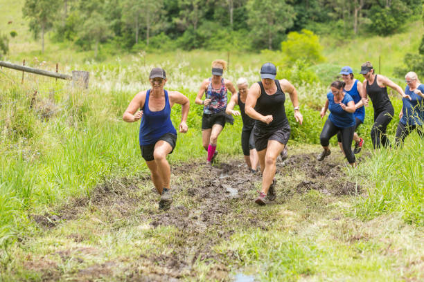 istock Mud Covered Mature Women in an Obstacle Course Bog 905836552