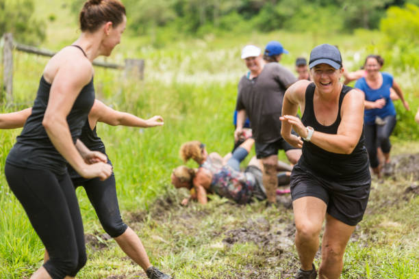 istock Mud Covered Mature Women in an Obstacle Course Bog 905836558