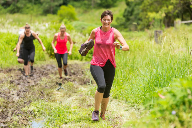 istock Mud Covered Mature Women in an Obstacle Course Bog 905836568