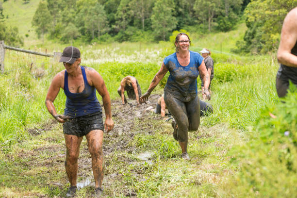 istock Mud Covered Mature Women in an Obstacle Course Bog 905836584