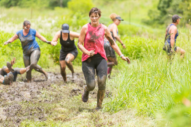 istock Mud Covered Mature Women in an Obstacle Course Bog 905836590