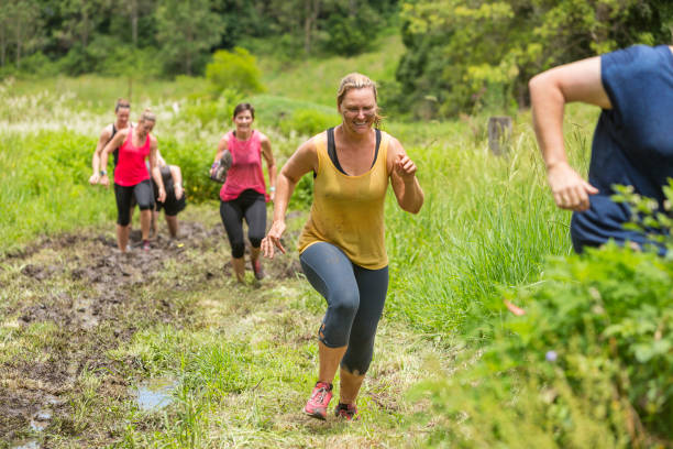 istock Mud Covered Mature Women in an Obstacle Course Bog 905836620
