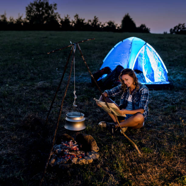 istock Female hiker resting by the fire 905841186