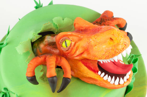 istock Art cake with dinosaur, decorated with green leaves. 905845704