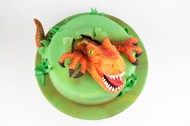 istock Art cake with dinosaur, decorated with green leaves. 905845898