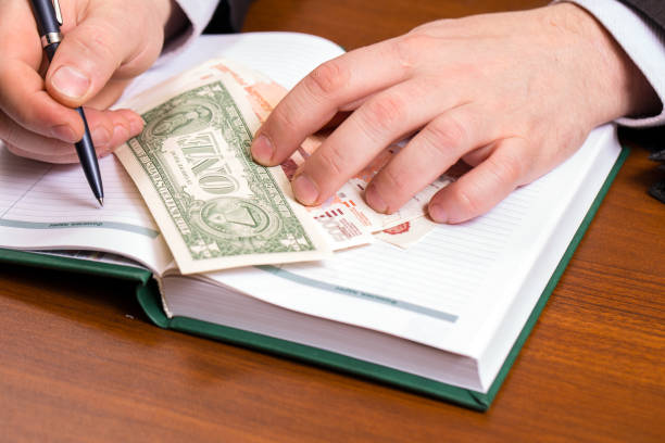 istock Businessman with a notebook and dollars 905849336