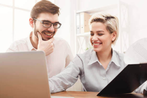istock Couple of young colleagues working at modern office 905849540