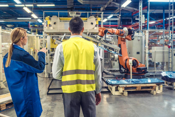 istock Female engineers explaining robotic arm working to colleague 905849720
