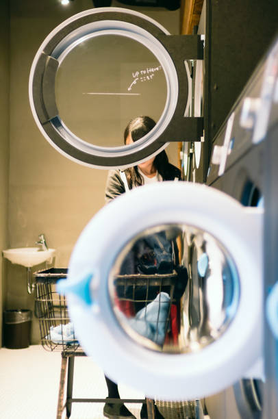 istock Young Woman Doing Laundry at Laundromat 905850022