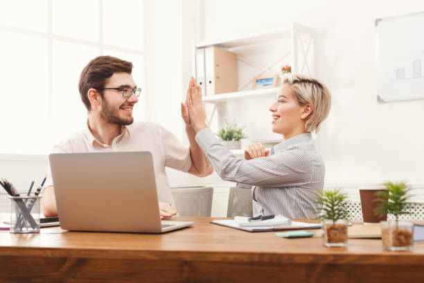 istock Young happy business partners in office with computer 905850146