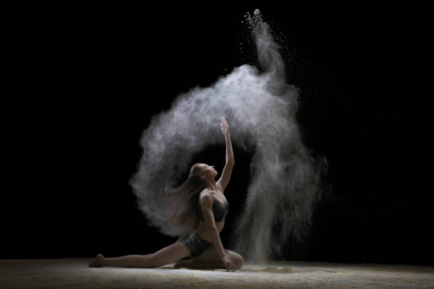 istock Young woman sitting in fine white dust cloud shot 905850346