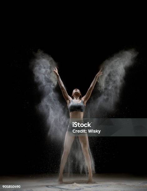 Girl In Top And Shorts In A White Dust Cloud Shot Stock Photo - Download Image Now - Acrobat, Acrobatic Activity, Active Lifestyle
