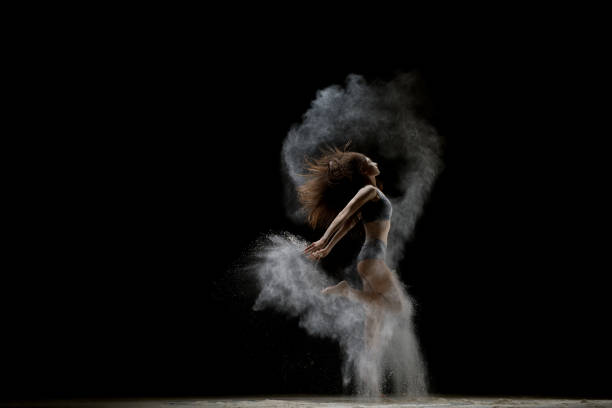 istock Girl jumping gracefully in a white dust cloud shot 905850718
