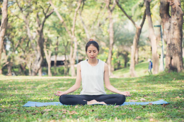 istock Young asian woman yoga outdoors keep calm and meditates while practicing yoga to explore the inner peace. Yoga and meditation have good benefits for health. Yoga Sport and Healthy lifestyle concept. 905853912