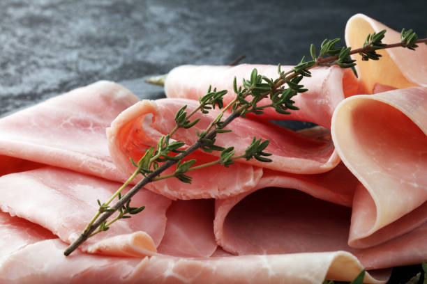 istock Sliced ham on stone background. Fresh prosciutto. Pork ham sliced. 905858236