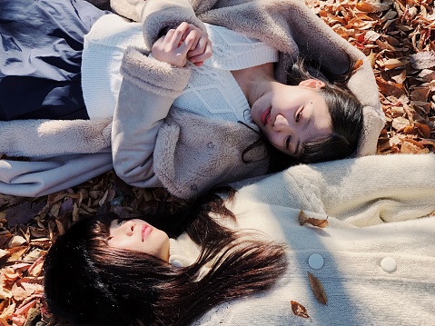 Portrait of two women on Woman Lying with eyes closed on Autumn Field
