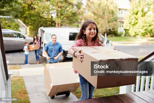 Children Helping Unload Boxes From Van On Family Moving In Day Stock Photo - Download Image Now