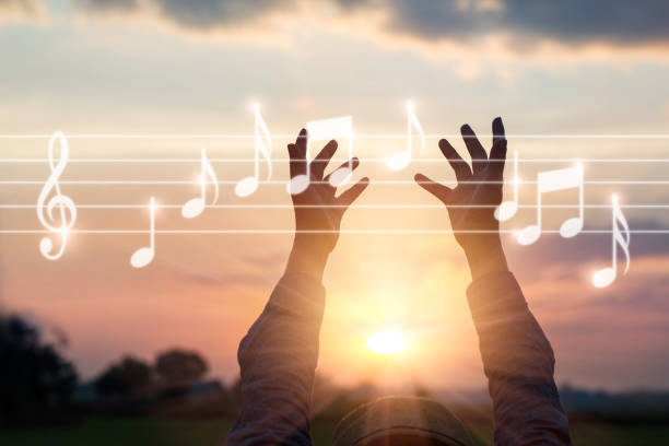 Abstract woman hands touching music notes on nature background, music concept Abstract woman hands touching music notes on nature background, music concept symphony orchestra photos stock pictures, royalty-free photos & images