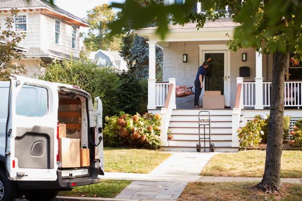 istock Courier Using Trolley To Deliver Package To House 905865382