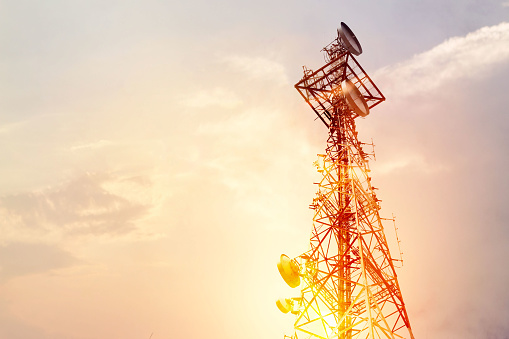 Abstracto de la telecomunicaciones torre antena y antena parabólica en el fondo del cielo al atardecer photo