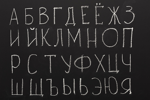 Russian alphabet written on black chalkboard. Cyrillic abc. Learning languages and education background