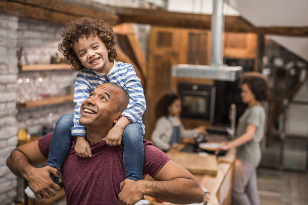 istock Happy African American father having fun with his boy while carrying him on shoulders. 905870020