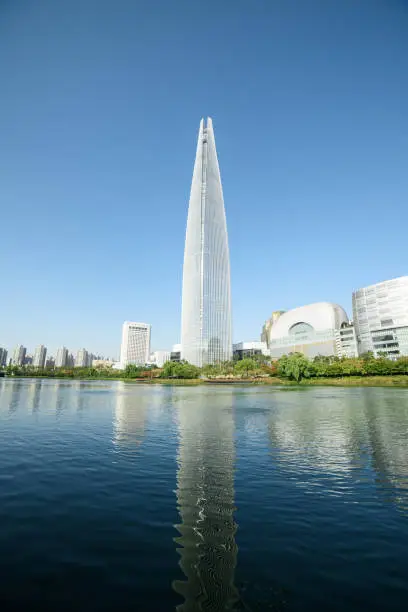 Wonderful view of skyscraper and other modern buildings at downtown of Seoul, South Korea. Amazing Seoul skyline. Modern tower on blue sky background reflected in water. Beautiful sunny cityscape.