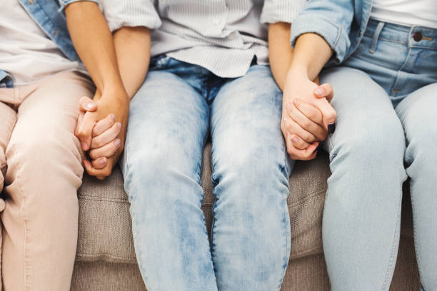 istock Three female friends holding hands closeup 905874732