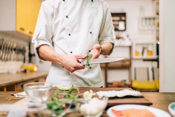 istock Male cook hands closeup, making sushi rolls 905878644